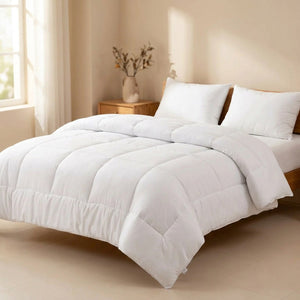 Couette d'hiver blanche moelleuse installée sur un lit fait dans une chambre chaleureuse