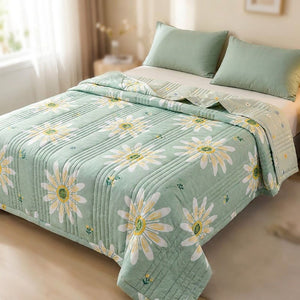 Couette d'été matelassée à motifs marguerites posée sur un lit dans une chambre lumineuse