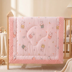 Couette bébé motif lapins étoilés avec bordure rose à pois dans un berceau