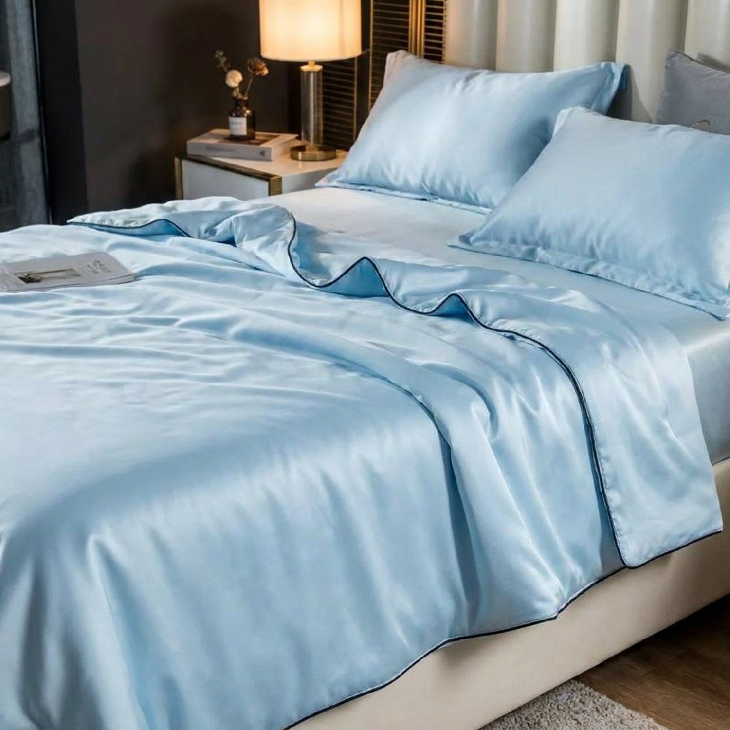 Couette d'été bleu ciel sur un lit avec table de chevet et lampe chaleureuse