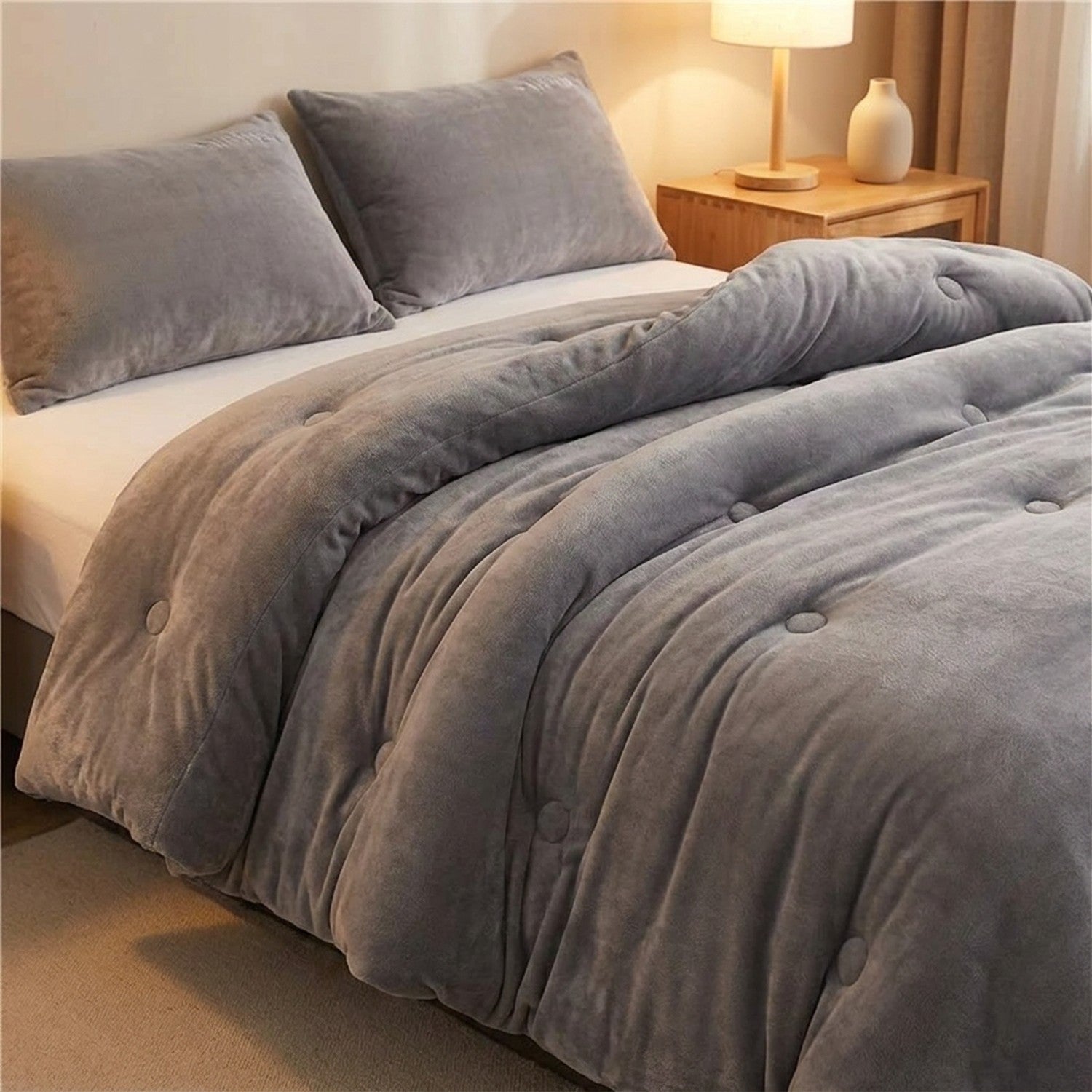 Couette grise en velours de lait matelassée sur un lit dans une chambre cosy
