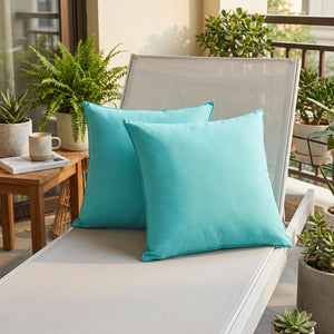 Coussins d'extérieur turquoise sur un transat de balcon entouré de plantes