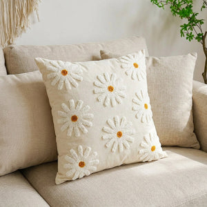 Détail de la broderie florale de la housse de coussin sur canapé lin beige