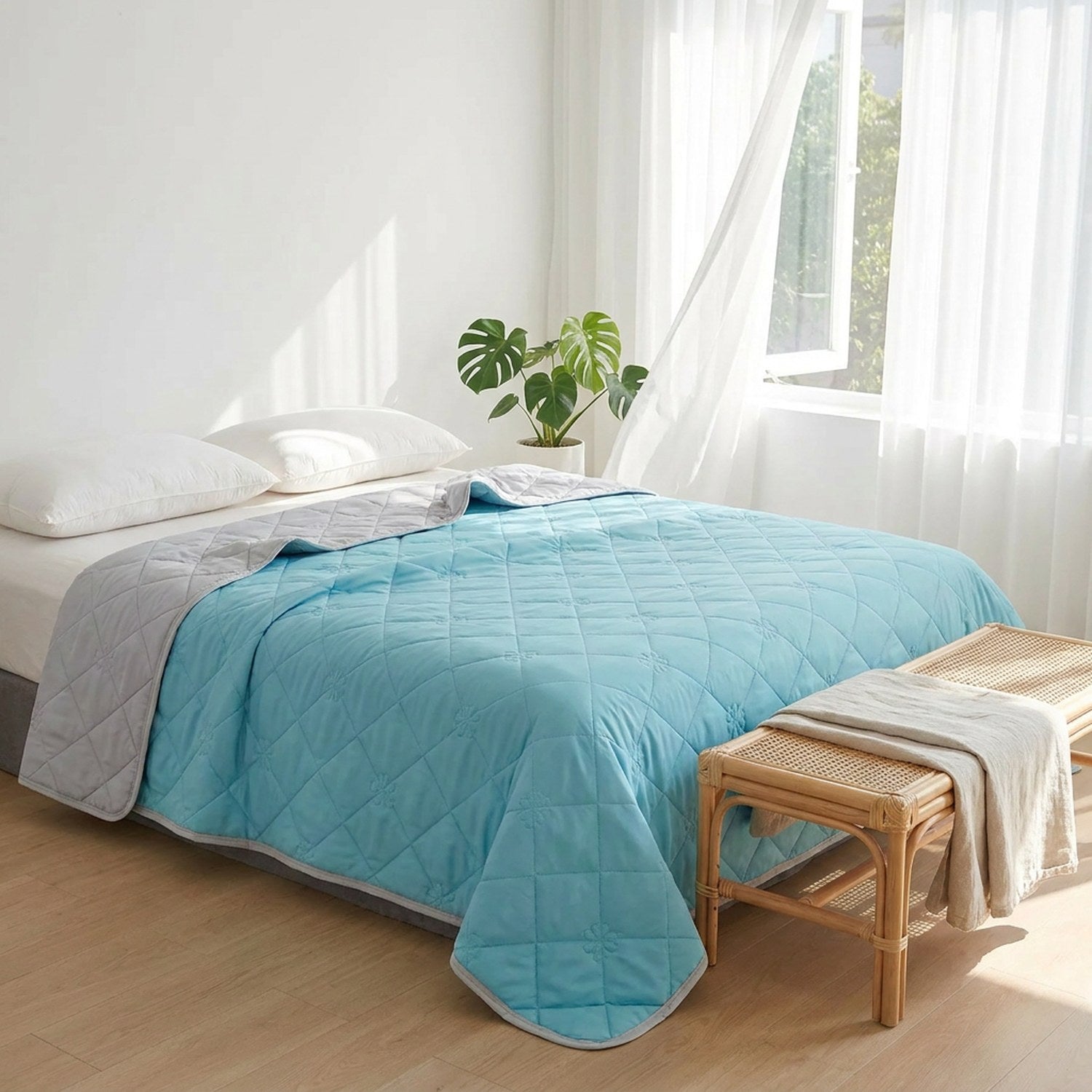 Couverture rafraîchissante bleue déployée sur un lit près d'une fenêtre ensoleillée
