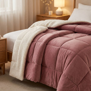 Couverture chaude réversible vieux rose en velours et effet mouton sur un lit cosy