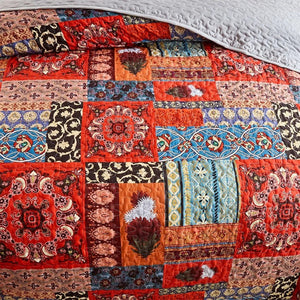 Détail du patchwork bohème aux carreaux rouille bleu et noir du couvre-lit