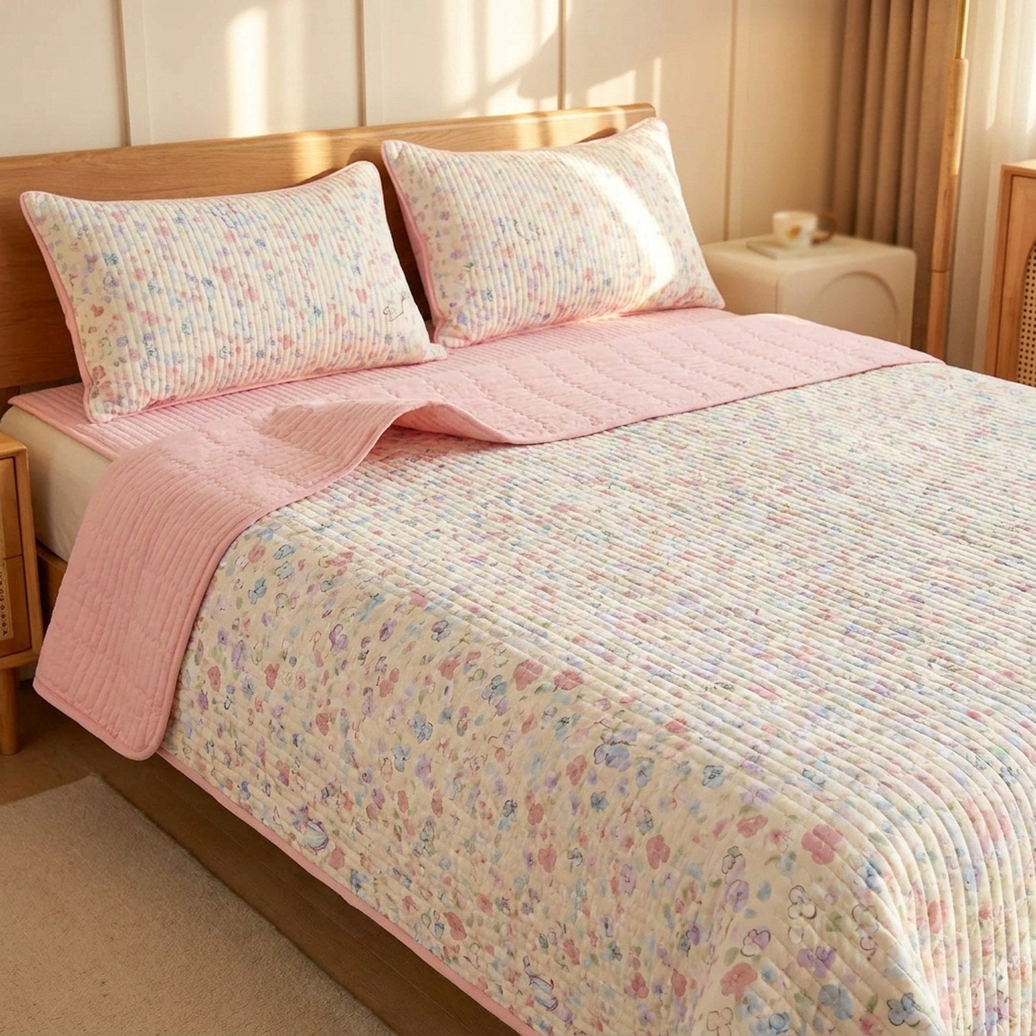 Couvre-lit matelassé fleuri pastel et envers rose sur un lit