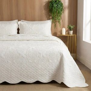 Couvre-lit matelassé blanc dans une chambre chaleureuse avec mur en bois et plante suspendue