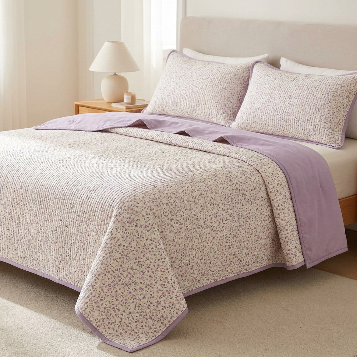 Couvre-lit matelassé imprimé floral violet posé sur un lit dans une chambre lumineuse