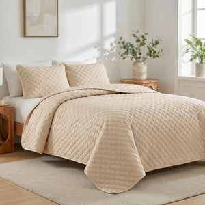 Couvre-lit matelassé beige au motif losange installé sur un lit dans une chambre chaleureuse
