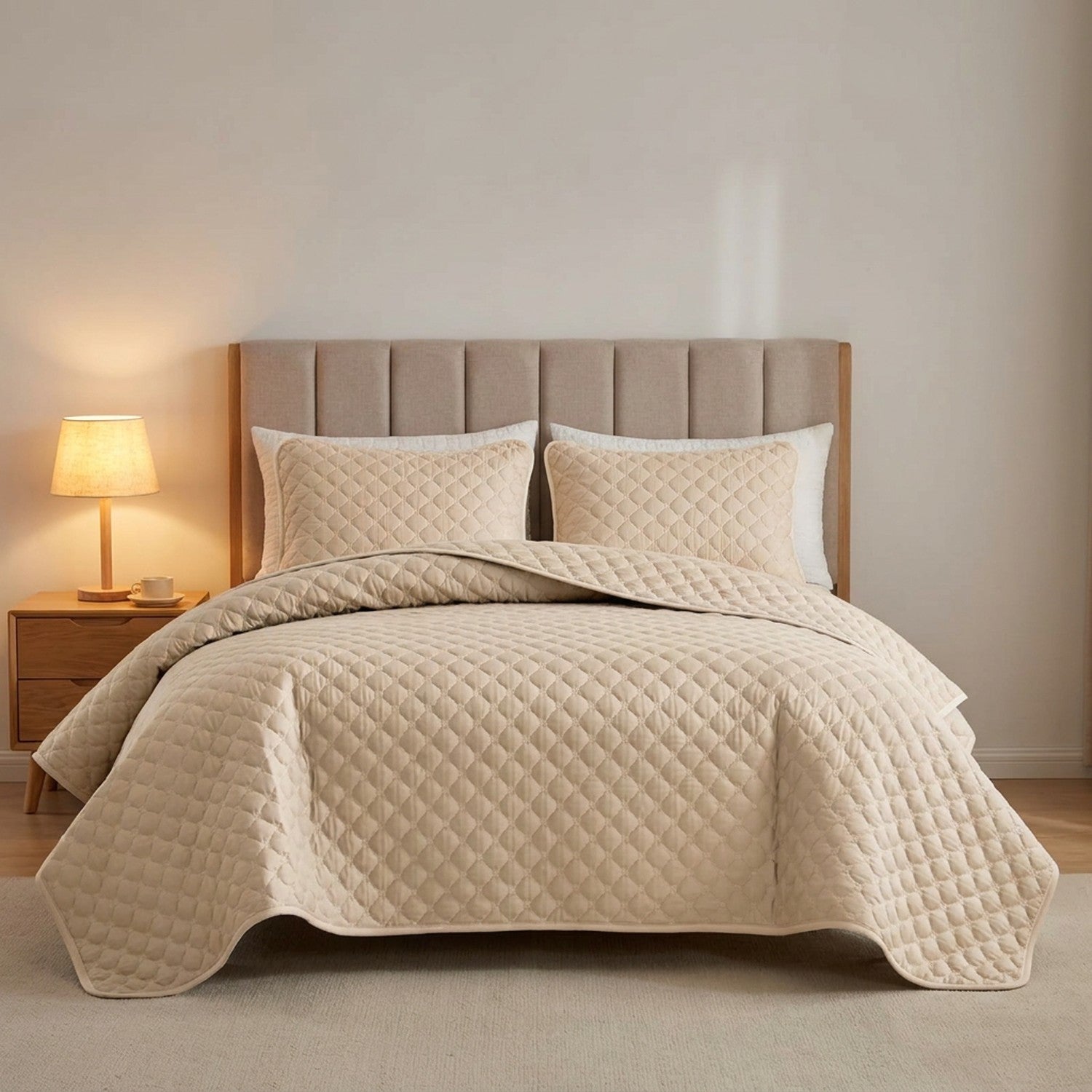 Couvre-lit matelassé beige sur un lit avec table de chevet et lampe chaleureuse