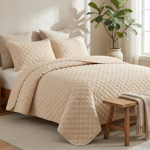 Couvre-lit matelassé beige sur un lit dans une chambre naturelle et douce