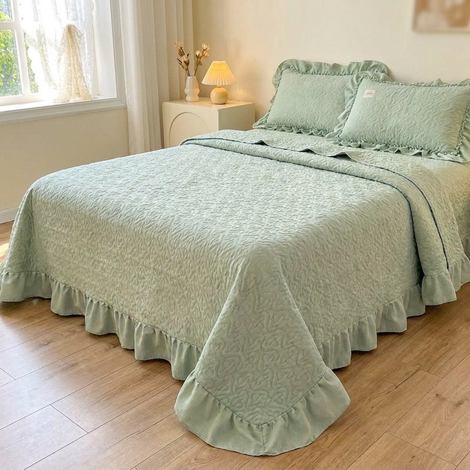 Couvre-lit matelassé vert sauge à motif de cœurs et volant sur un lit