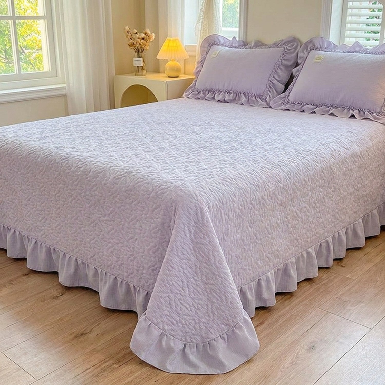 Couvre-lit matelassé violet à motif de cœurs et volant sur un lit