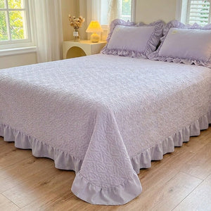 Couvre-lit matelassé violet à motif de cœurs et volant sur un lit