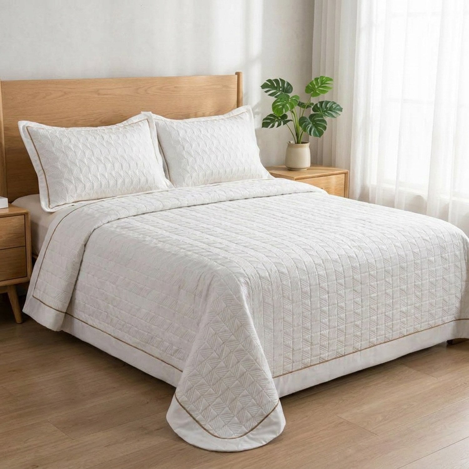 Couvre-lit matelassé blanc installé sur un lit dans une chambre lumineuse et épurée
