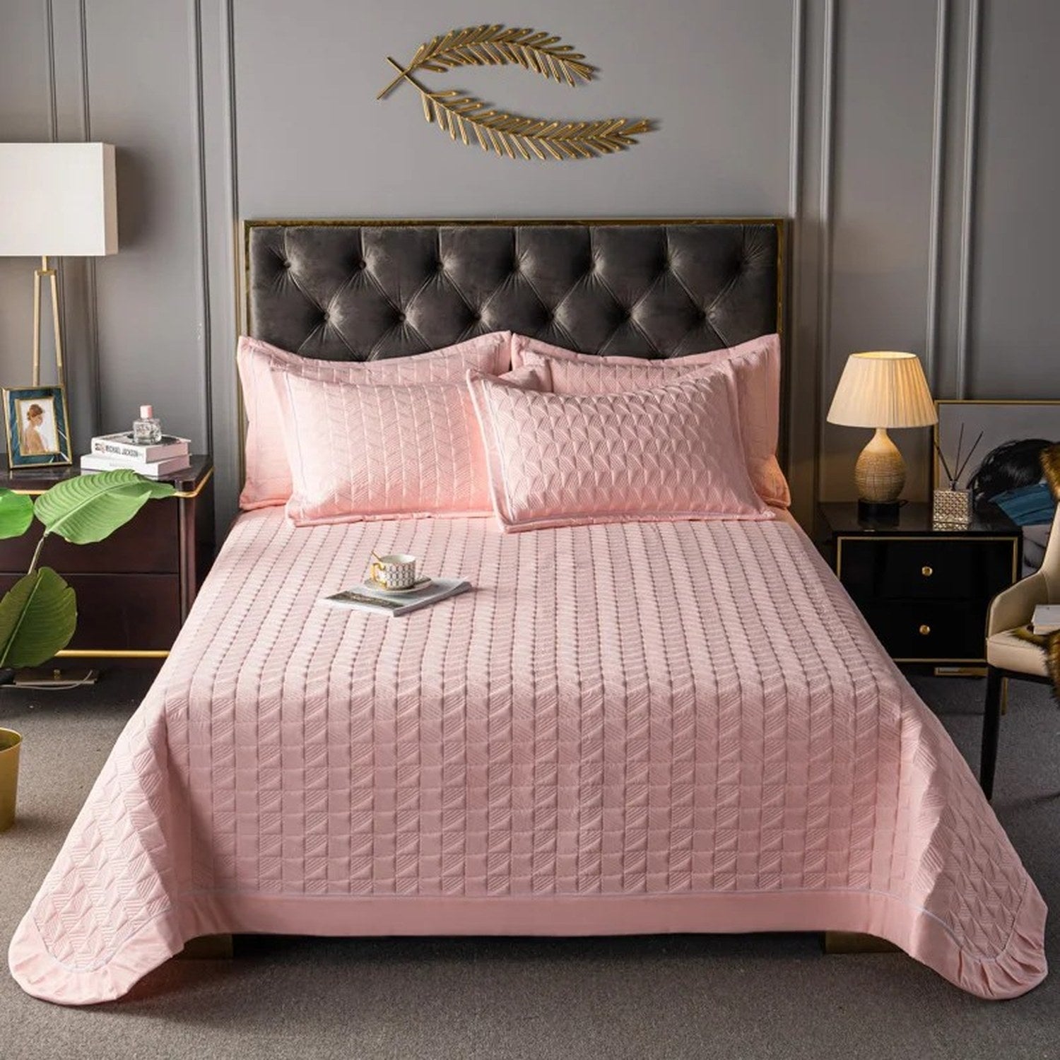 Couvre-lit matelassé rose avec deux taies assorties sur un lit