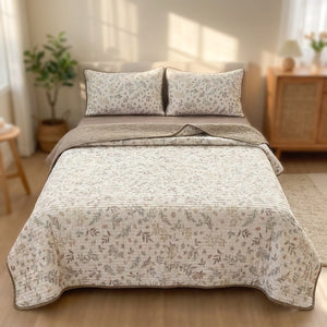 Couvre-lit matelassé à roses anciennes taupe et envers taupe sur un lit