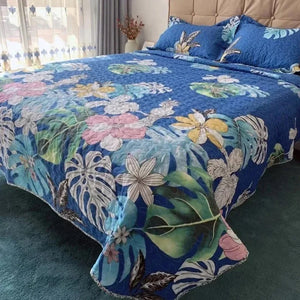 Couvre-lit matelassé imprimé feuillage tropical sur fond bleu sur un lit