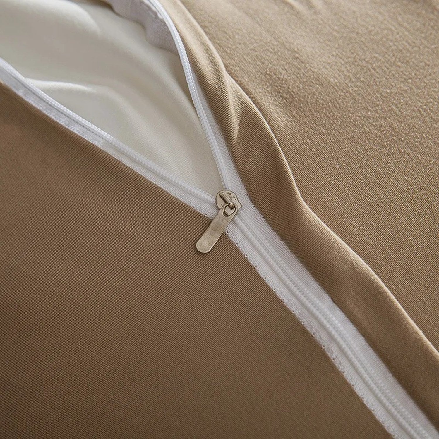 Détail de la fermeture éclair et du tissu velours beige du couvre-lit