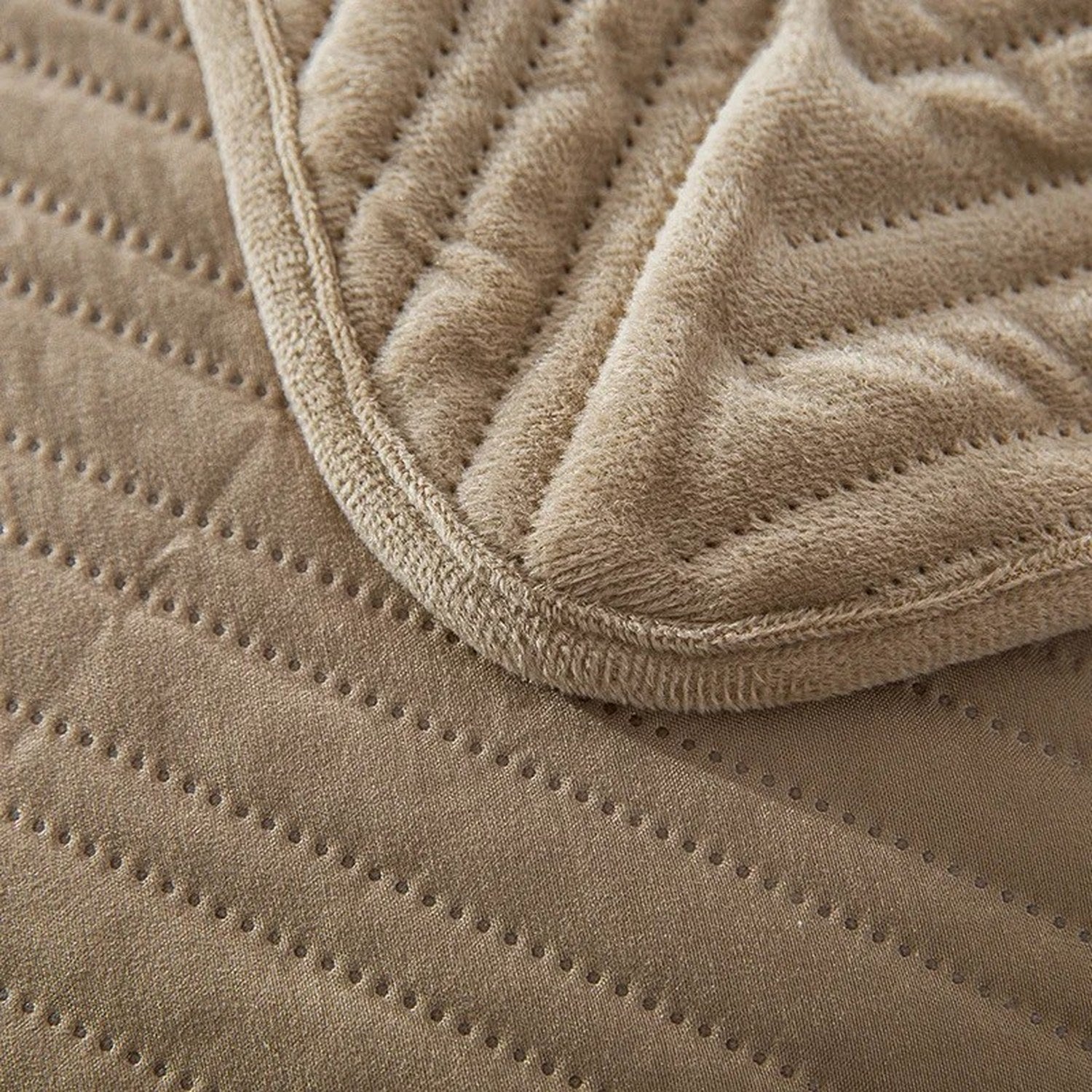 Gros plan sur la texture velours et le piqué géométrique du couvre-lit