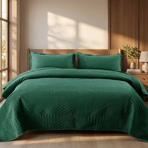 Couvre-lit matelassé velours vert foncé avec taies assorties sur un lit