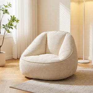 Fauteuil pouf en velours côtelé crème dans une pièce lumineuse