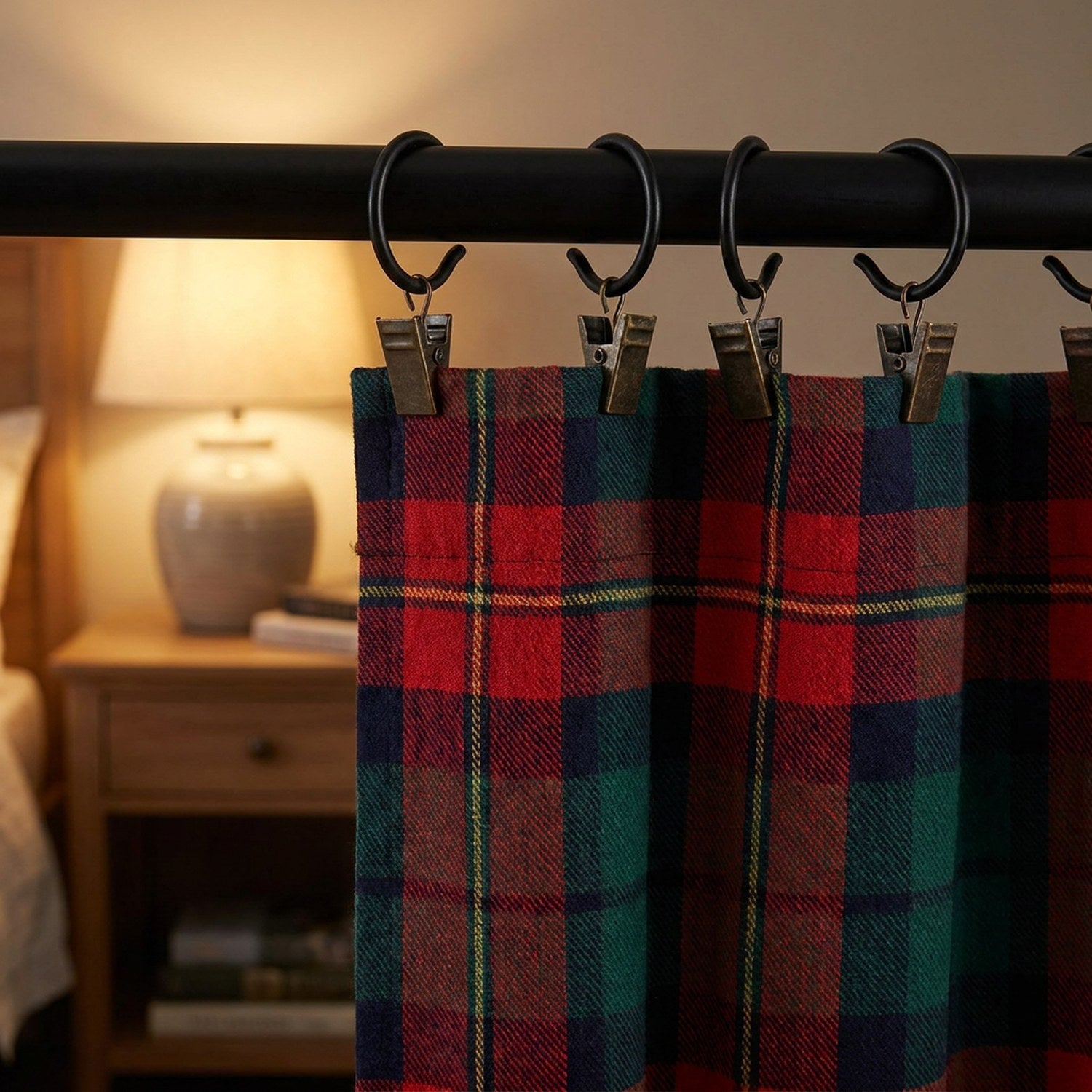 Rideau tartan fixé par des crochets à clip bronze antique dans une chambre chaleureuse