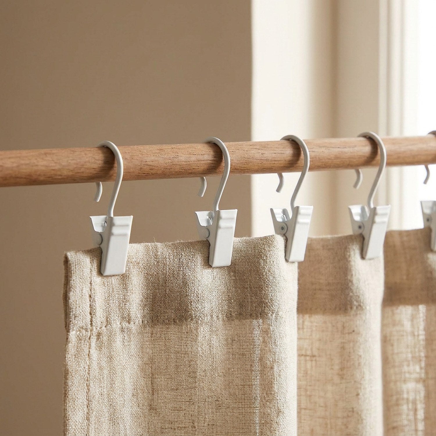 Crochets de rideau à clip en métal blanc accrochés à une tringle en bois
