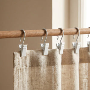 Crochets de rideau à clip en métal blanc accrochés à une tringle en bois