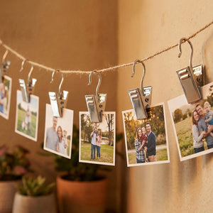 Crochets pinces suspendus à une ficelle tenant des photos de famille sur un mur
