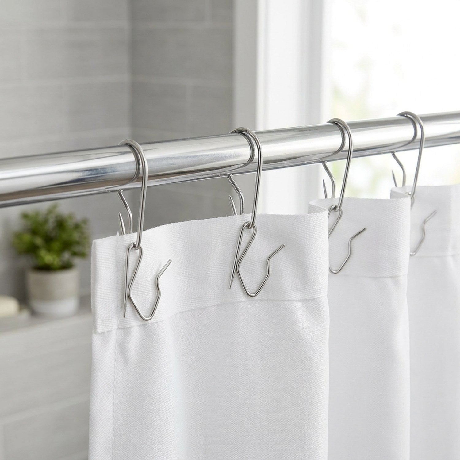 Rideau de douche blanc suspendu par des crochets métalliques dans une salle de bain