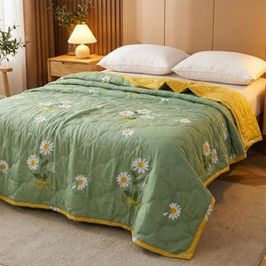 Couvre-lit vert à marguerites sur un lit avec lampe de chevet chaleureuse