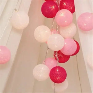 Guirlande lumineuse boules de coton rose dans escalier