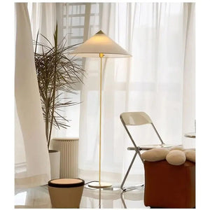 Lampadaire abat-jour tissu blanc dans un salon lumineux voilages plantes