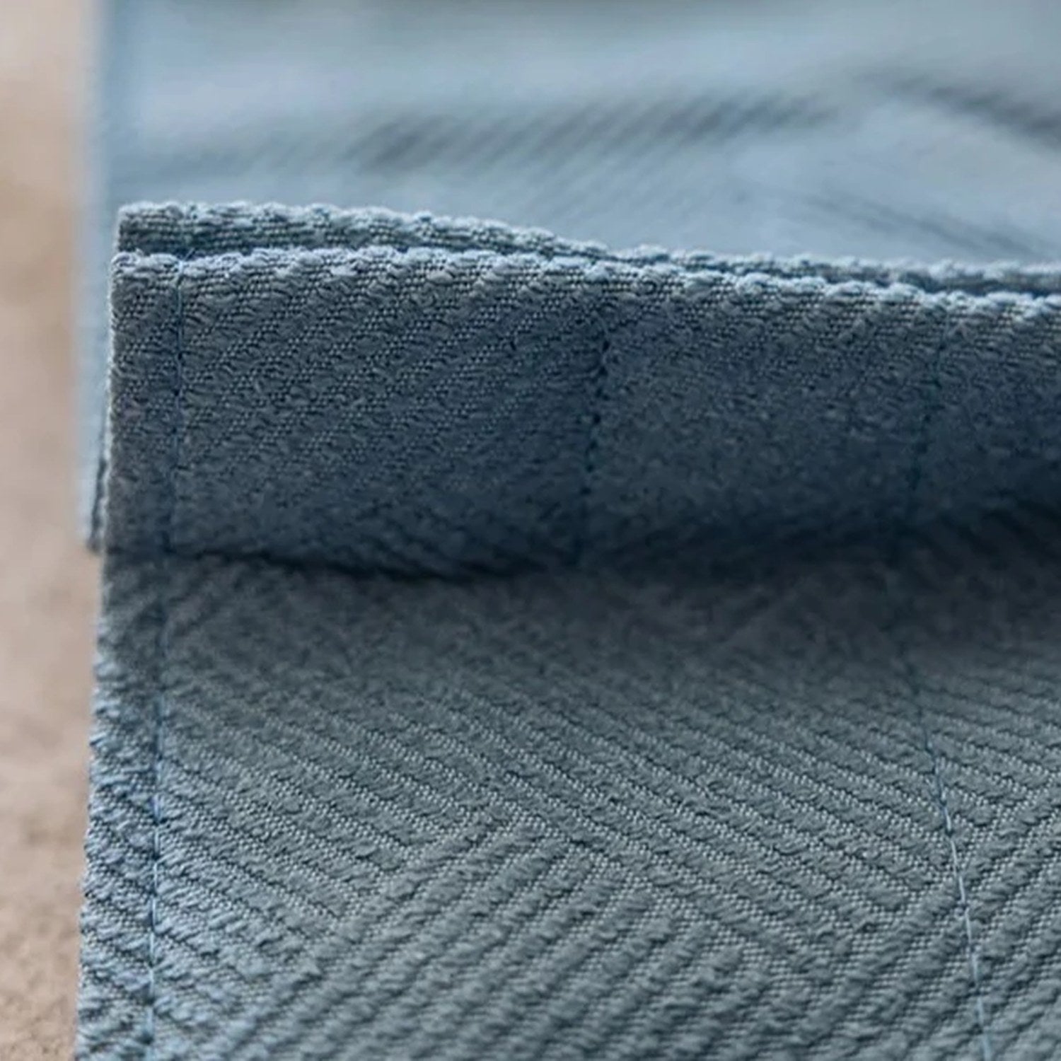 Gros plan sur le tissage chevron du rideau occultant coloris bleu