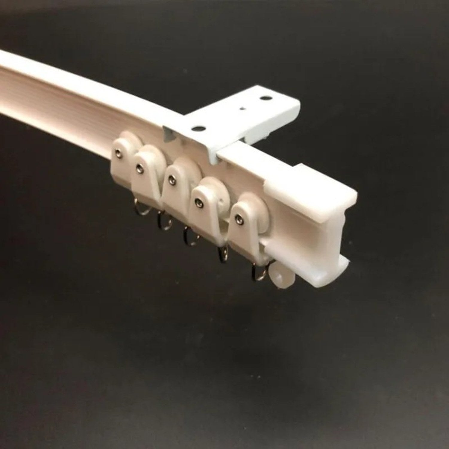 Detail du rail de rideau blanc avec glissieres et anneaux metalliques