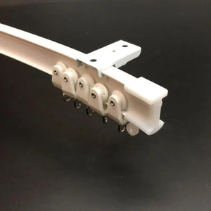 Detail du rail de rideau blanc avec glissieres et anneaux metalliques