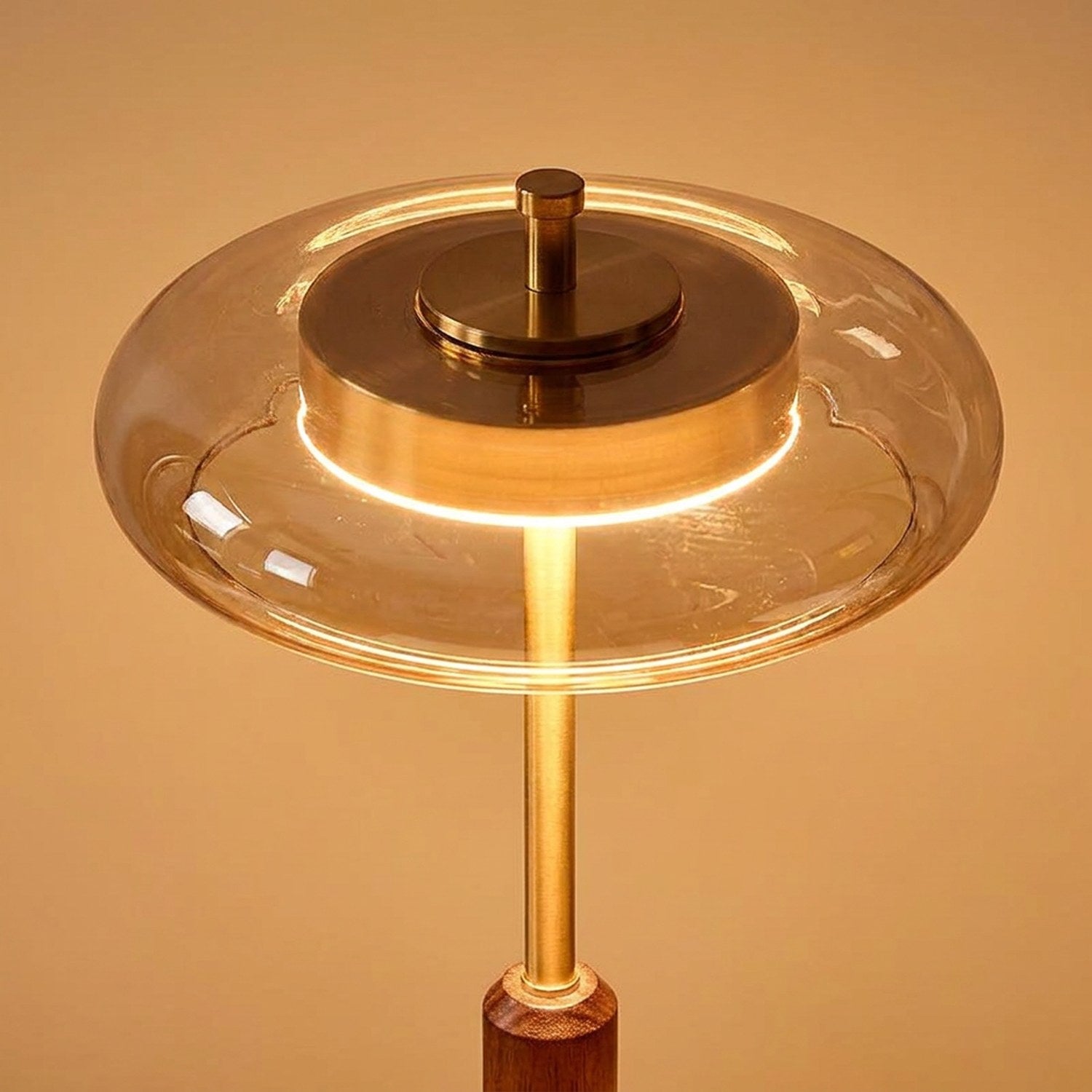 Gros plan sur l'abat-jour en verre ambré et le laiton de la lampe vintage allumée