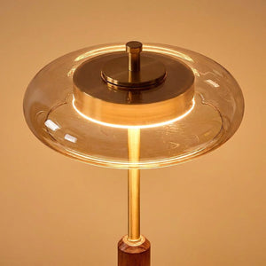 Gros plan sur l'abat-jour en verre ambré et le laiton de la lampe vintage allumée