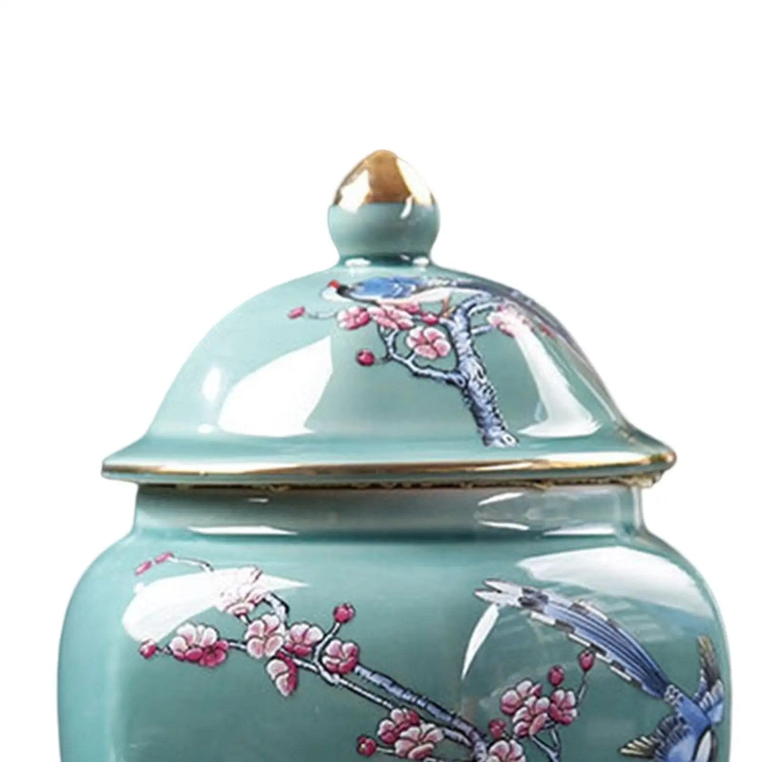 Détail du couvercle en céramique turquoise avec prise dorée et fleurs de prunier
