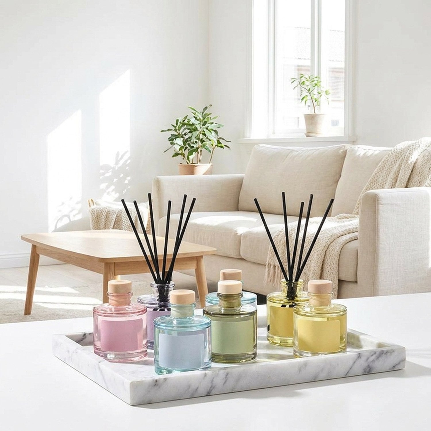 Collection diffuseurs à bâtonnets 50 ml, plusieurs parfums sur plateau marbre