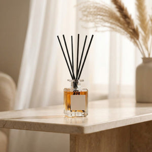 Diffuseur de parfum à bâtonnets sur une console en marbre près d'une fenêtre voilée