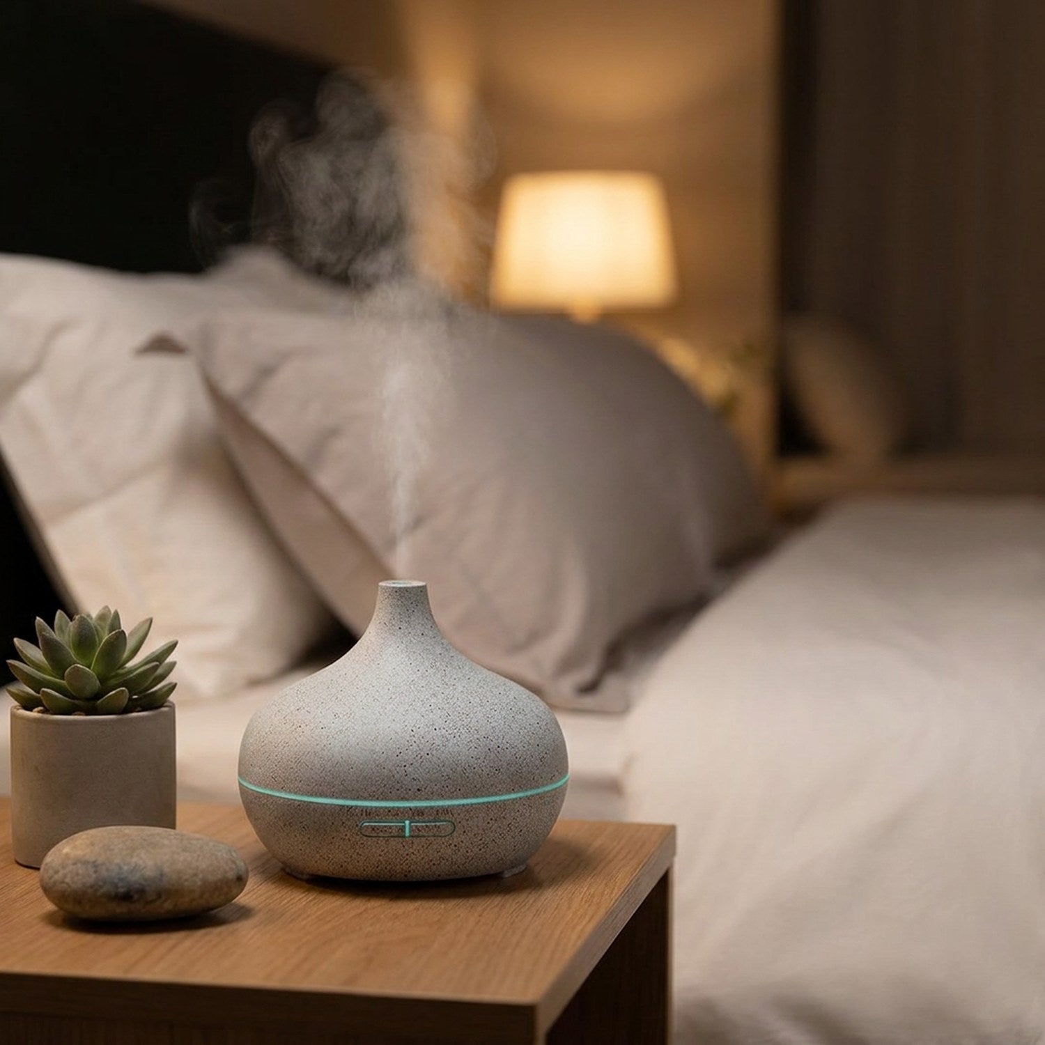 Diffuseur d'arômes motif pierre sur table de chevet, chambre cosy nocturne avec lumière LED teal et brume apaisante