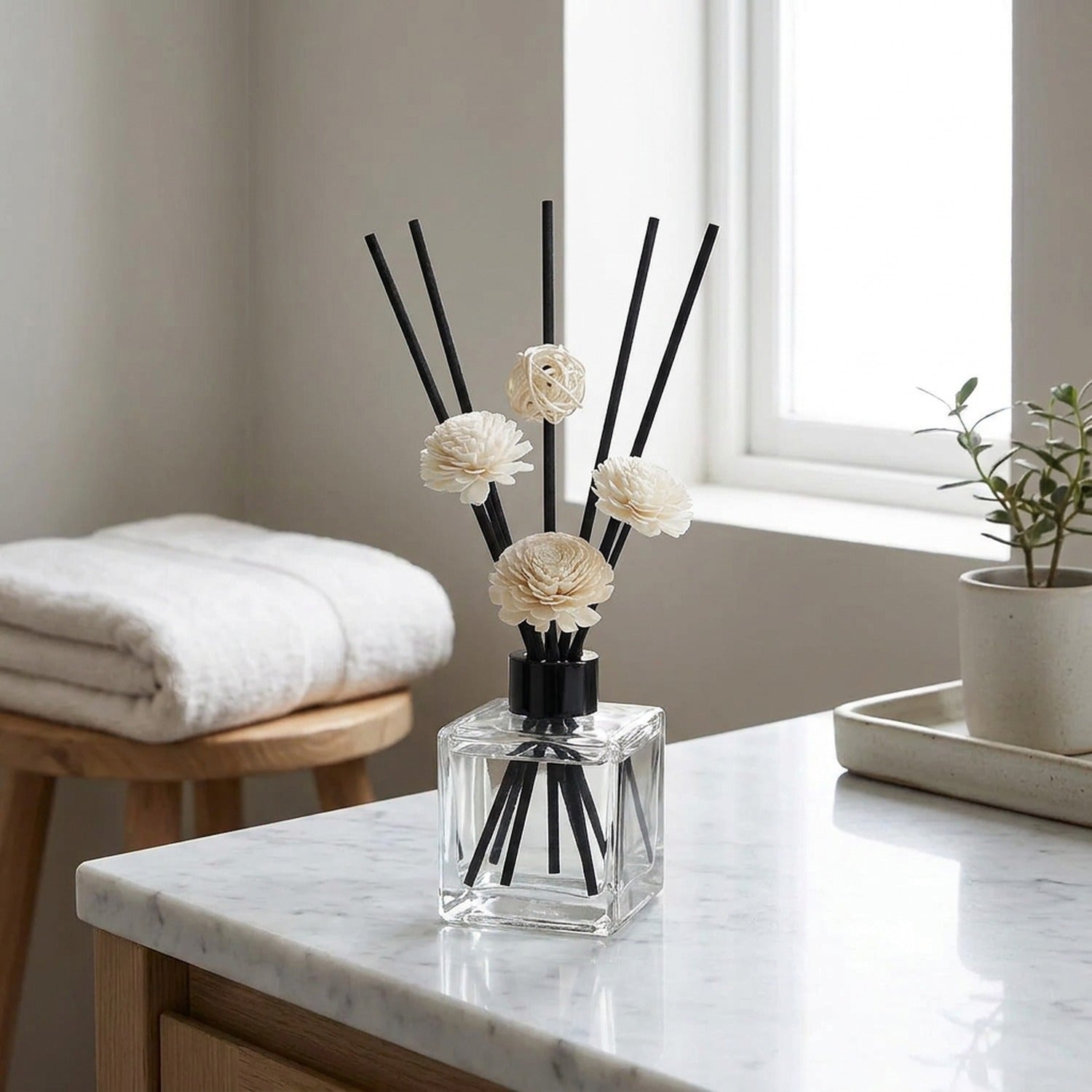 Diffuseur de parfum bâtonnets sur plan de travail marbre salle de bain épurée