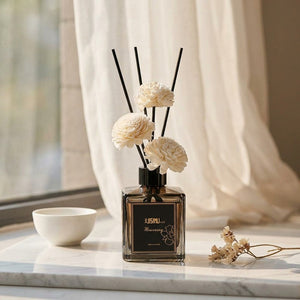 Diffuseur de roseaux sur surface marbre fenêtre voilage blanc lumière naturelle