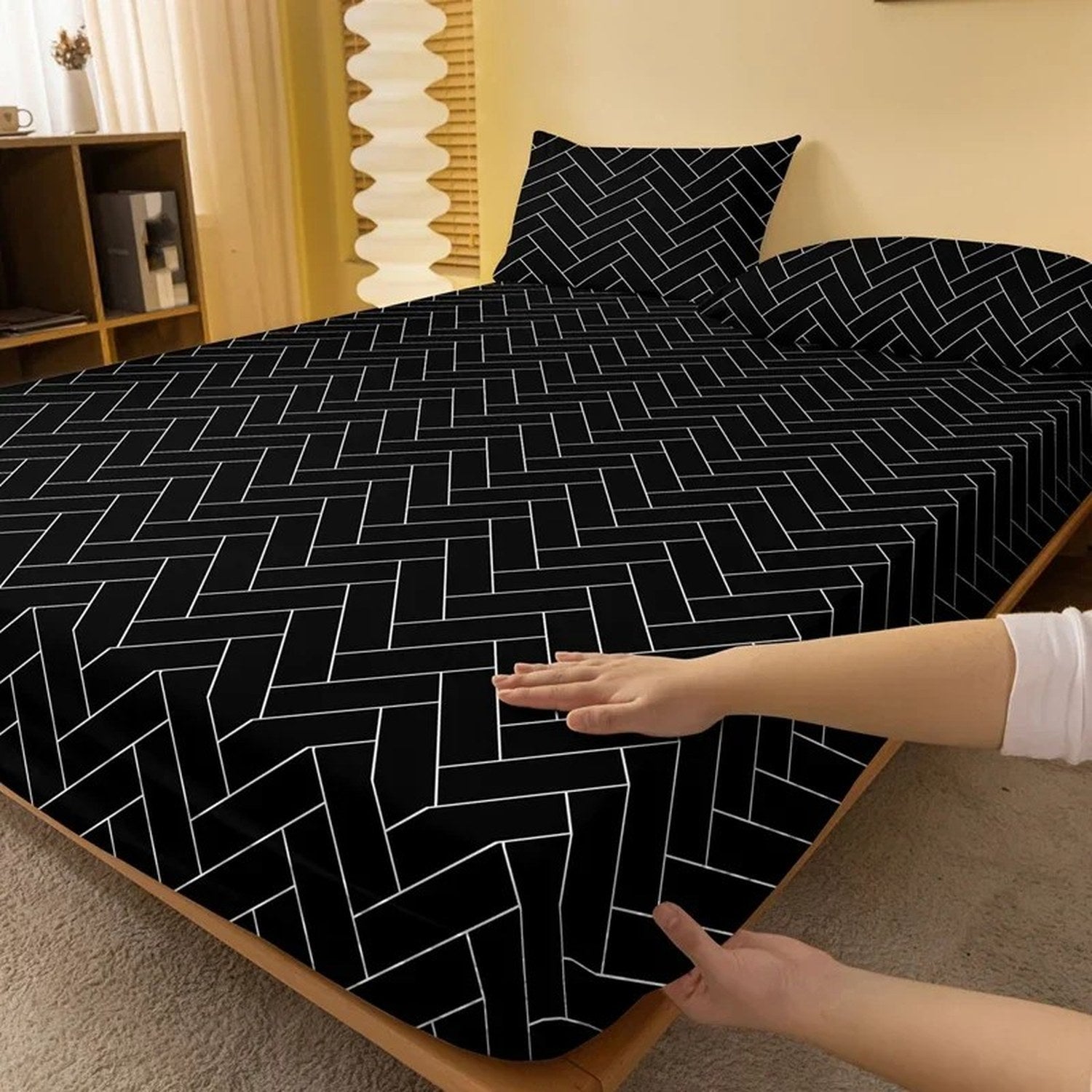Coin élastiqué du drap housse chevrons tiré à la main sur le matelas