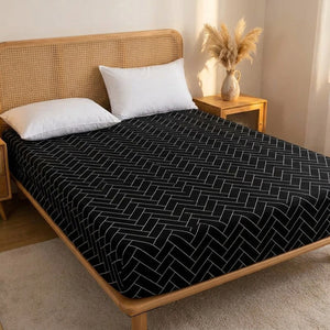 Drap housse chevrons noir et blanc dans une chambre scandinave avec tête de lit en rotin