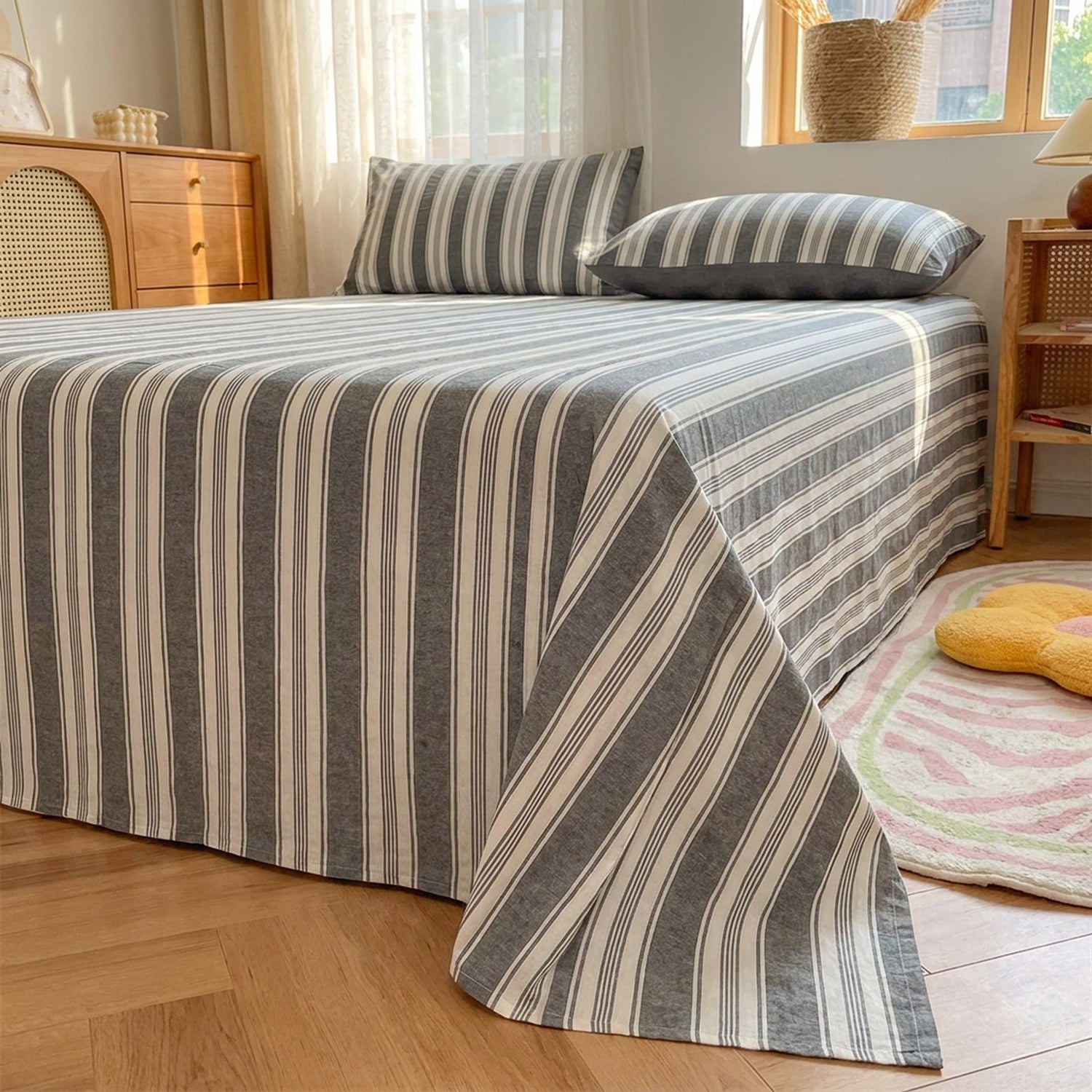 Drap plat gris rayé en coton fait sur un lit dans une chambre lumineuse au style japonais