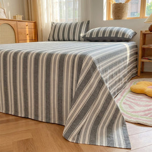 Drap plat gris rayé en coton fait sur un lit dans une chambre lumineuse au style japonais
